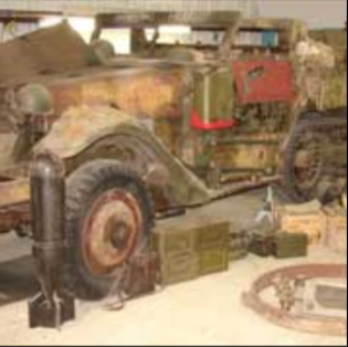 Halftrack full side view with equipment in museum collecting parts