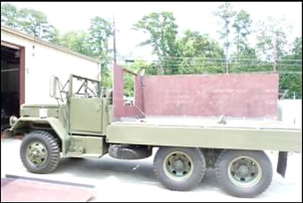 Side view of the restored 1958 Deuce-and-a-Half outside the building
