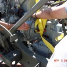 Hands working on engine installation inside halftrack frame