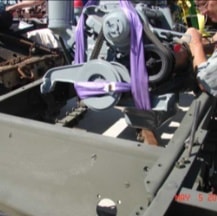 Purple lifting straps securing engine during halftrack installation