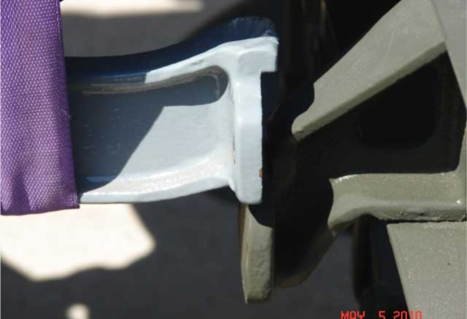 Close-up of freshly painted white bracket with purple lifting straps during engine installation