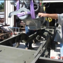 Close-up of engine being set into halftrack frame