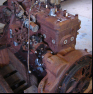 Heavily corroded halftrack engine block in barn before restoration