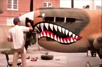Artist painting shark mouth nose art on P-40